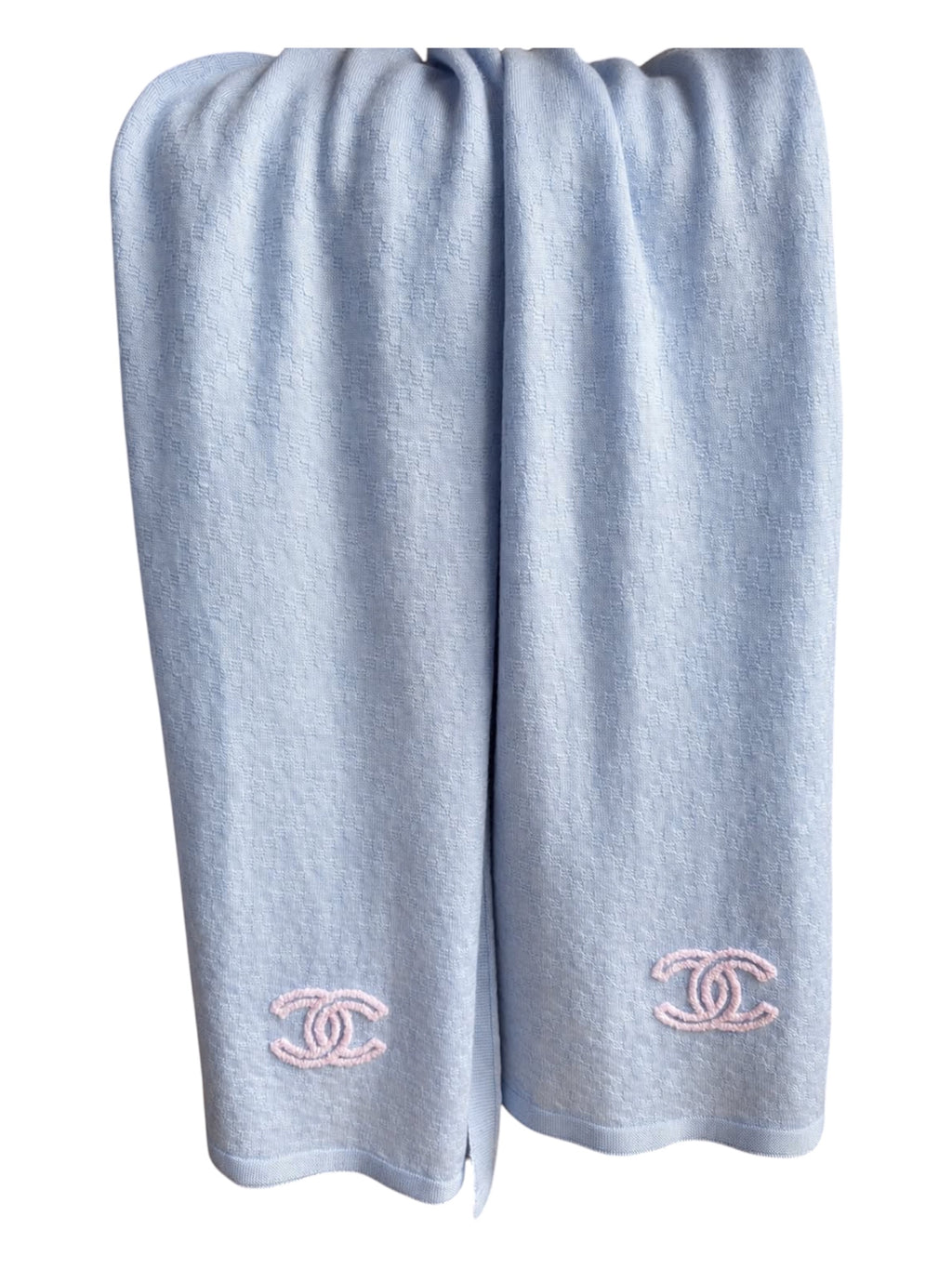 A light blue Chanel scarf with double CC pink embroidered Chanel logos near the bottom, shown against a plain white background.