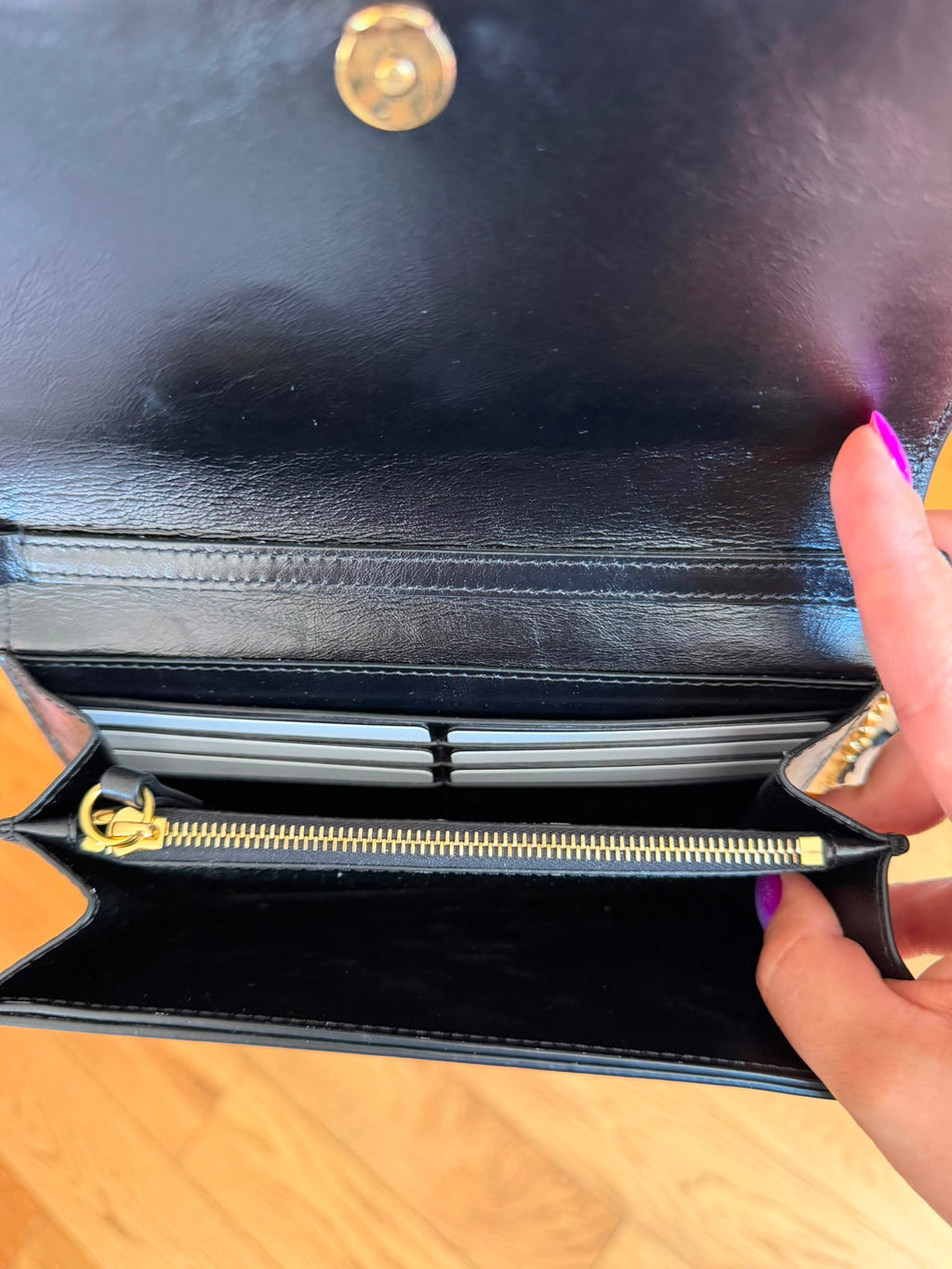 Interior view of Chloé black leather wallet on chain bag showing its compartments and storage space.