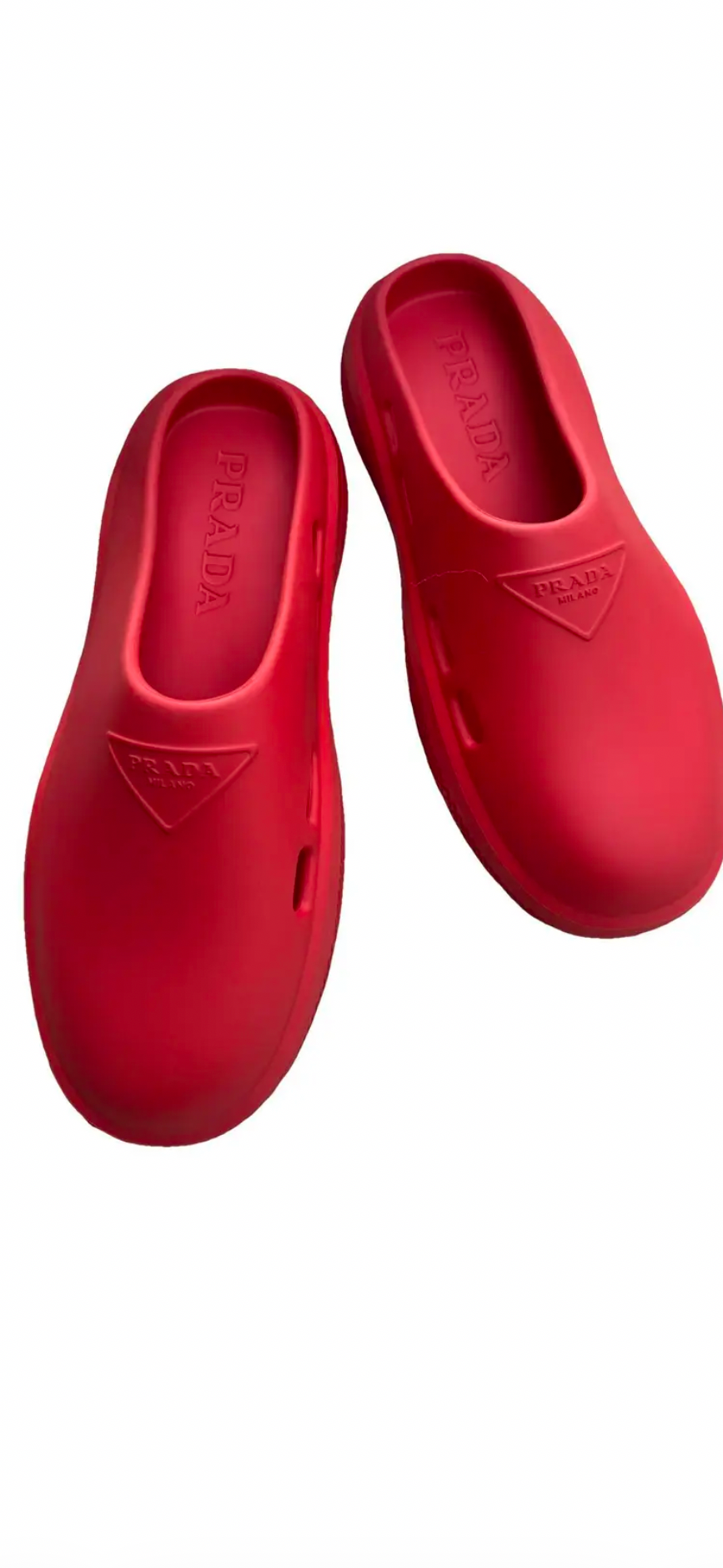 A pair of red slip-on clogs with a triangular logo on the side, shown on a white background within a mobile browser screenshot.
